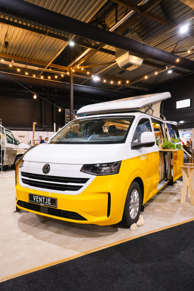 Geel-witte Ventje-camper op een beurs