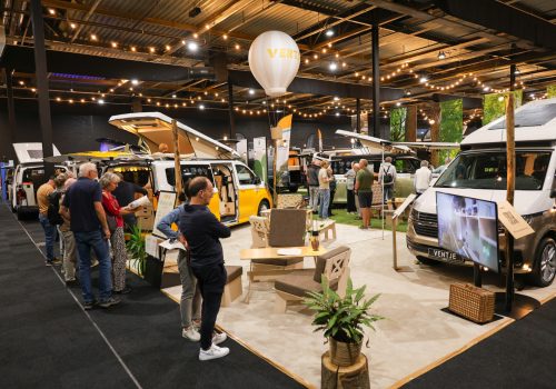 Bezoekers bekijken Ventje-campers op een beurs