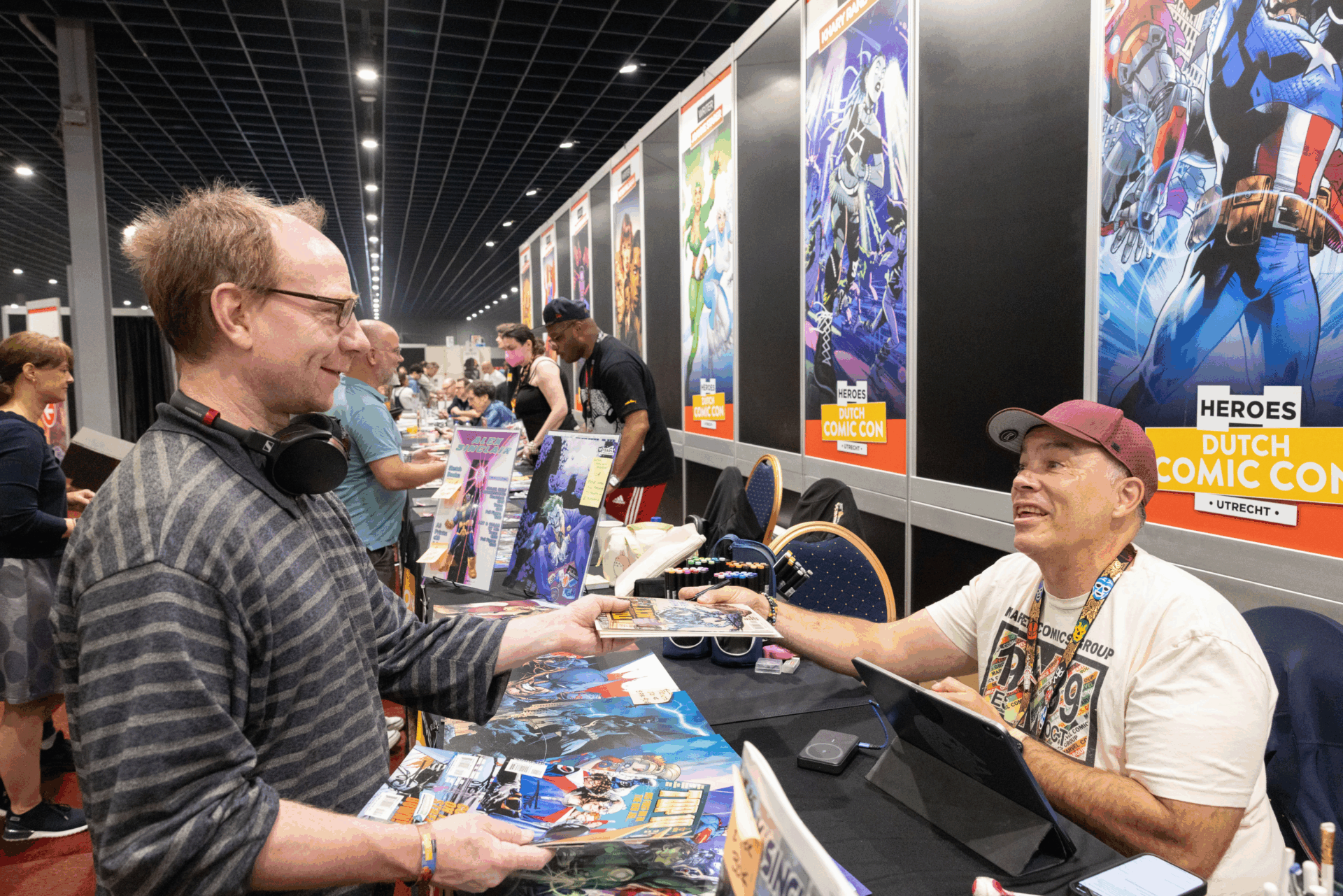 Comic fan receiving feedback on portfolio by comic artist at Heroes Dutch Comic Con