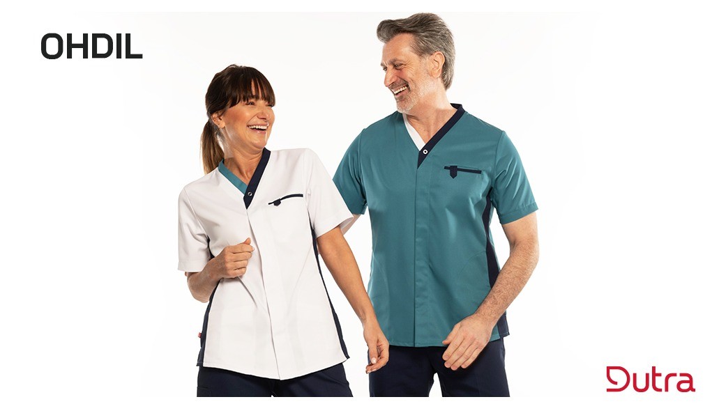 Moderne look met V-hals en comfortplooien op de rug. Borstzak met penvakje en interne zijzakken. Versterkte schaarzak. Verborgen drukknoopsluiting, contrasterende zijpanelen en zijsplitten zorgen voor extra stijl en comfort.