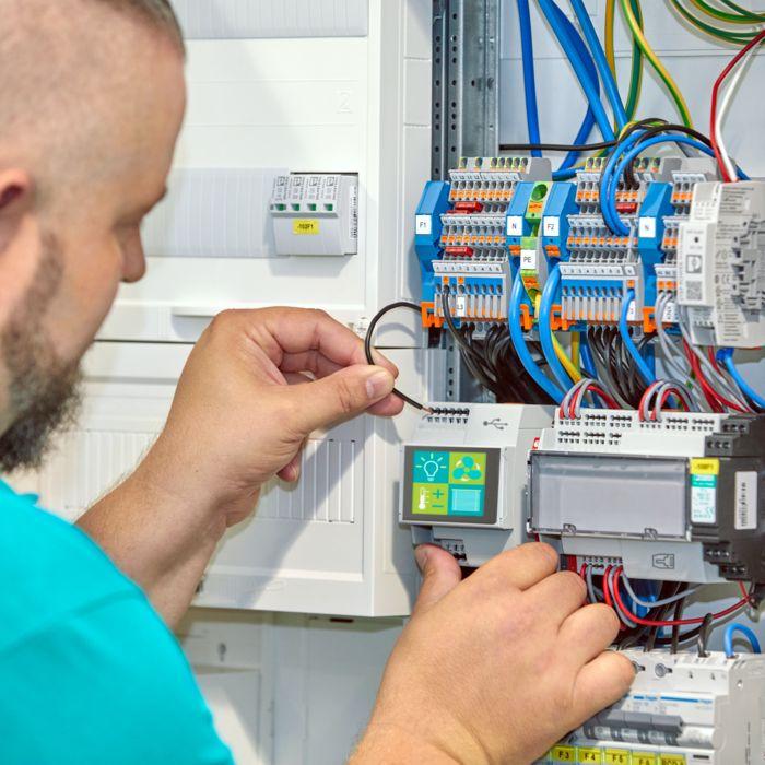 Elektricien installeert regelmodule in een meterkast