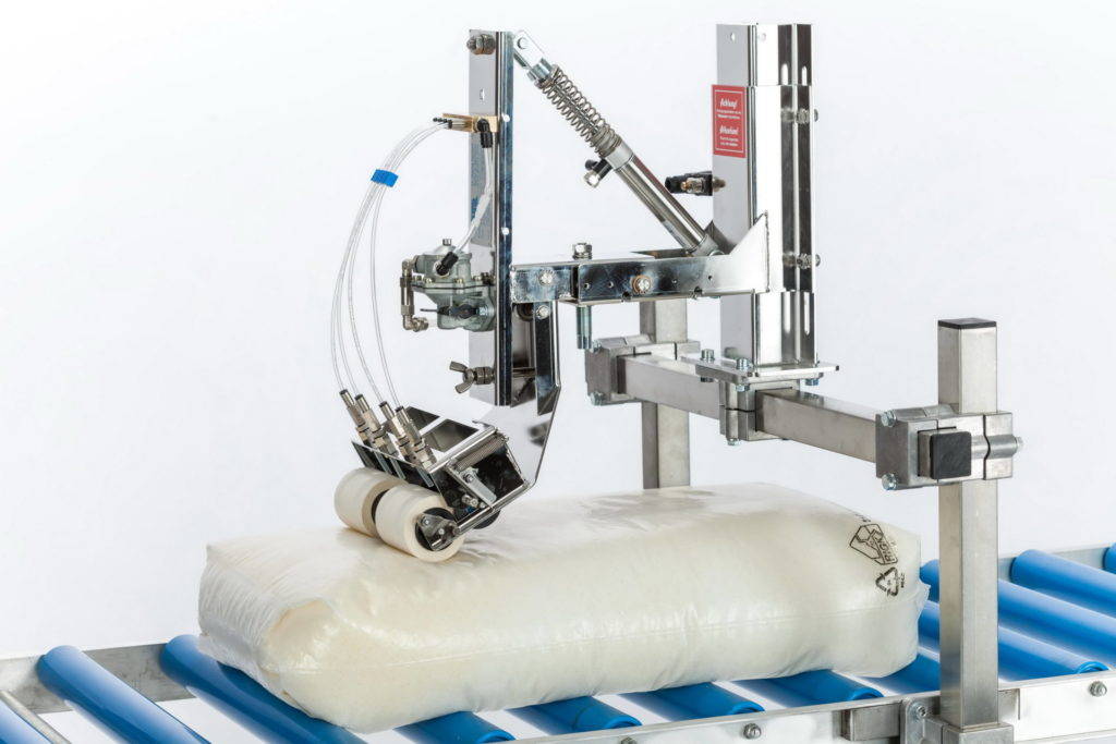 Tallpack International demonstreert lading zekeren middels koudlijm.