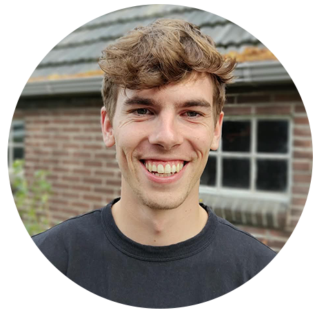 Glimlachende jonge man voor bakstenen muur