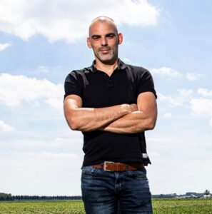 Kale man met gekruiste armen in groen veld