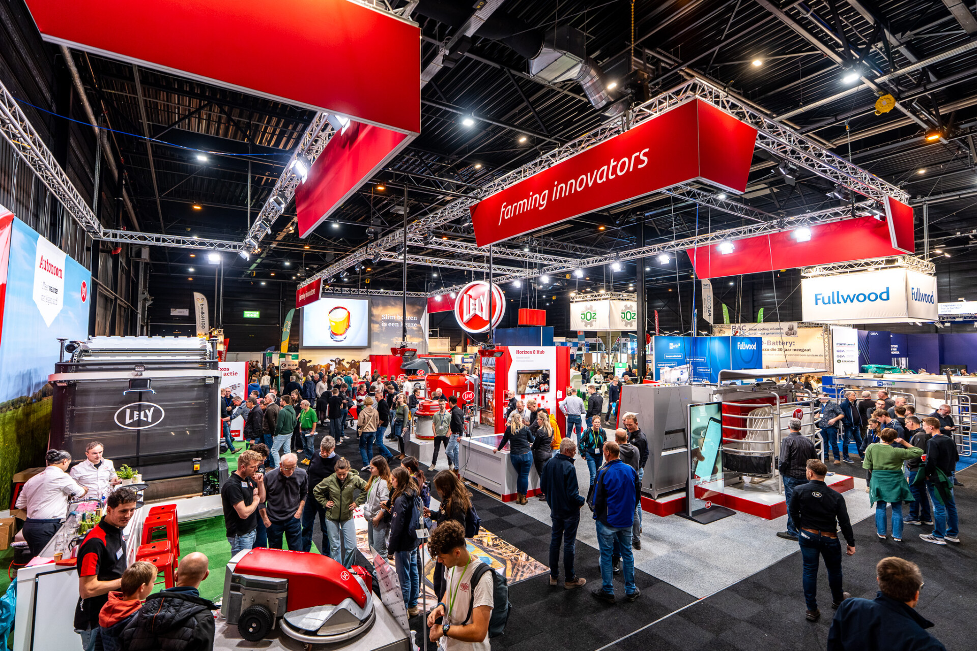 Drukke landbouwbeurs met Lely-stand en melkveetechnologie