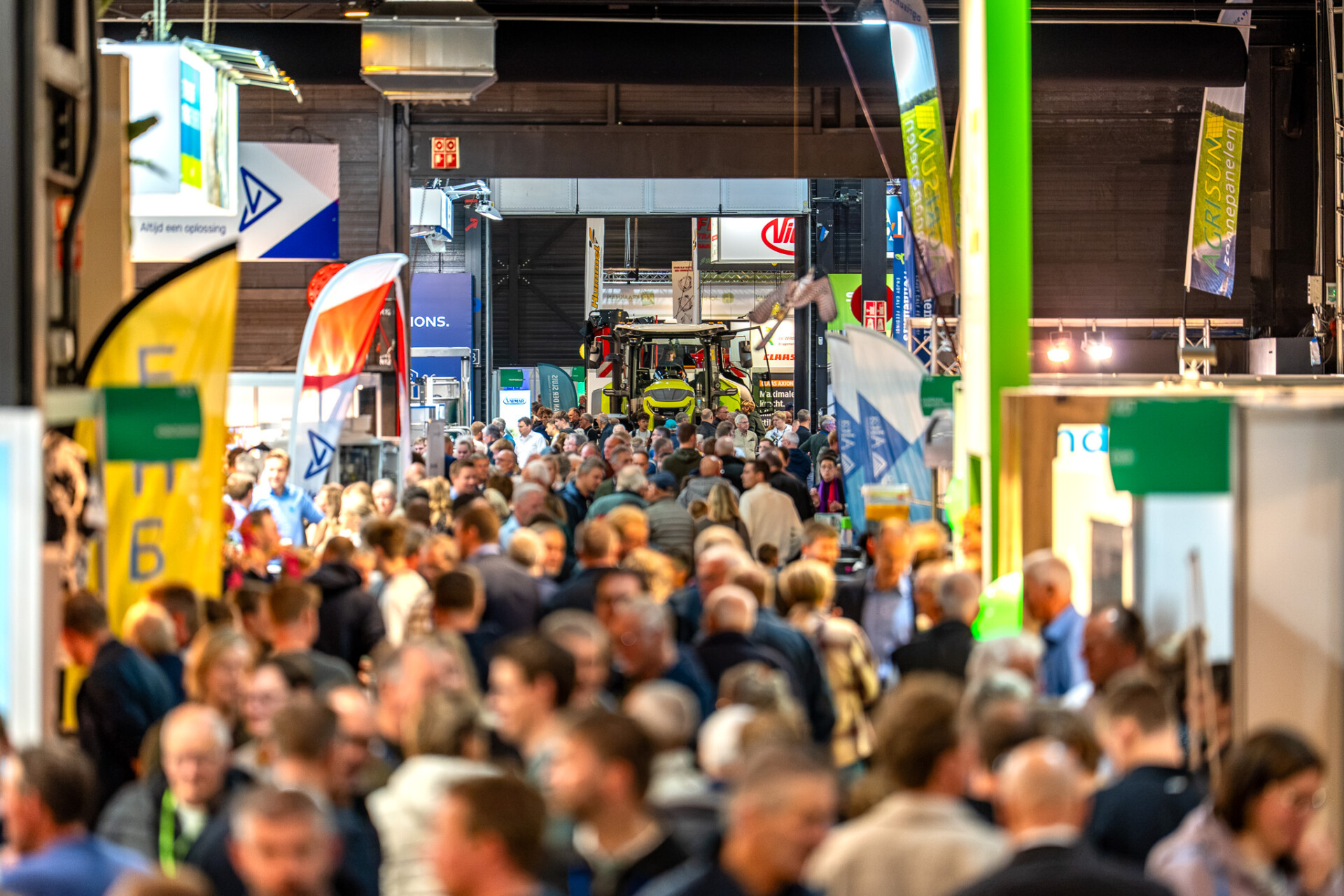Drukke bezoekersgang op agrarische vakbeurs met tractor