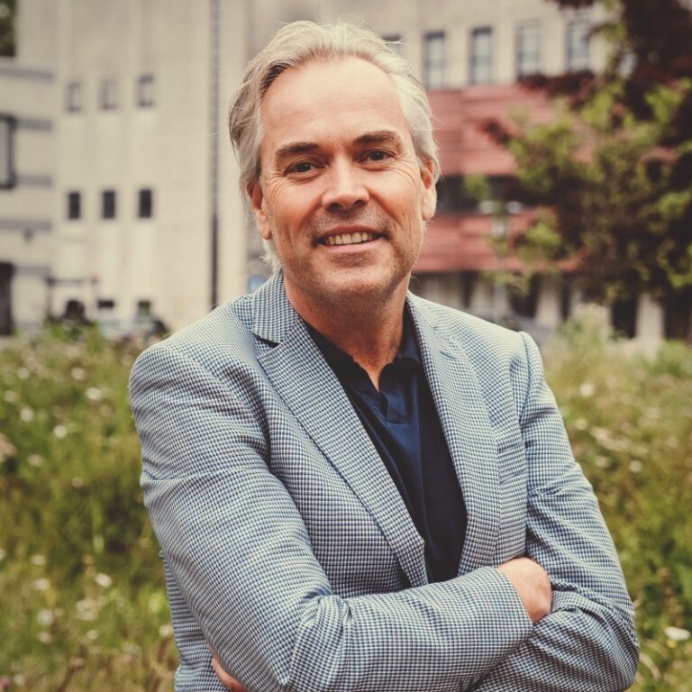 Glimlachende man in geruite blazer buiten