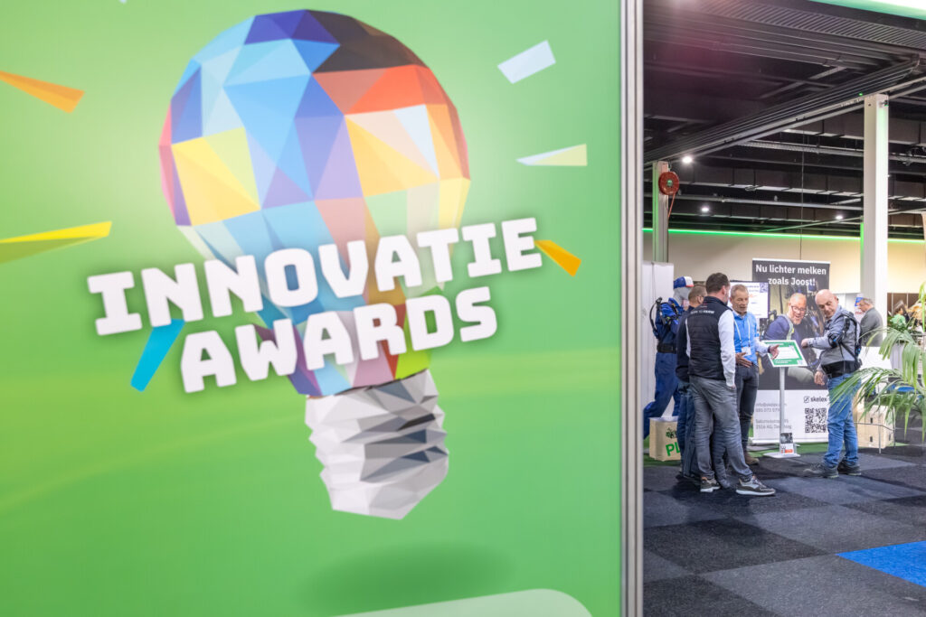 Innovatiebeurs met kleurrijke lamp en bezoekers bij stand