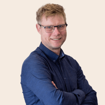 Portret van glimlachende man met bril en blauwe trui