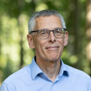 Portret van glimlachende man met bril in groene omgeving