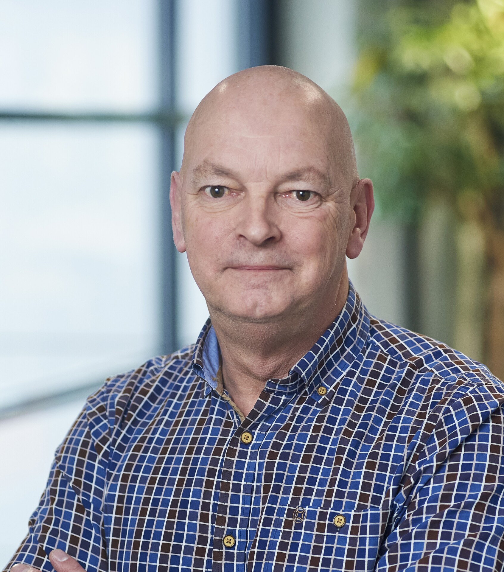 Portret van kalende man in geruit blauw overhemd