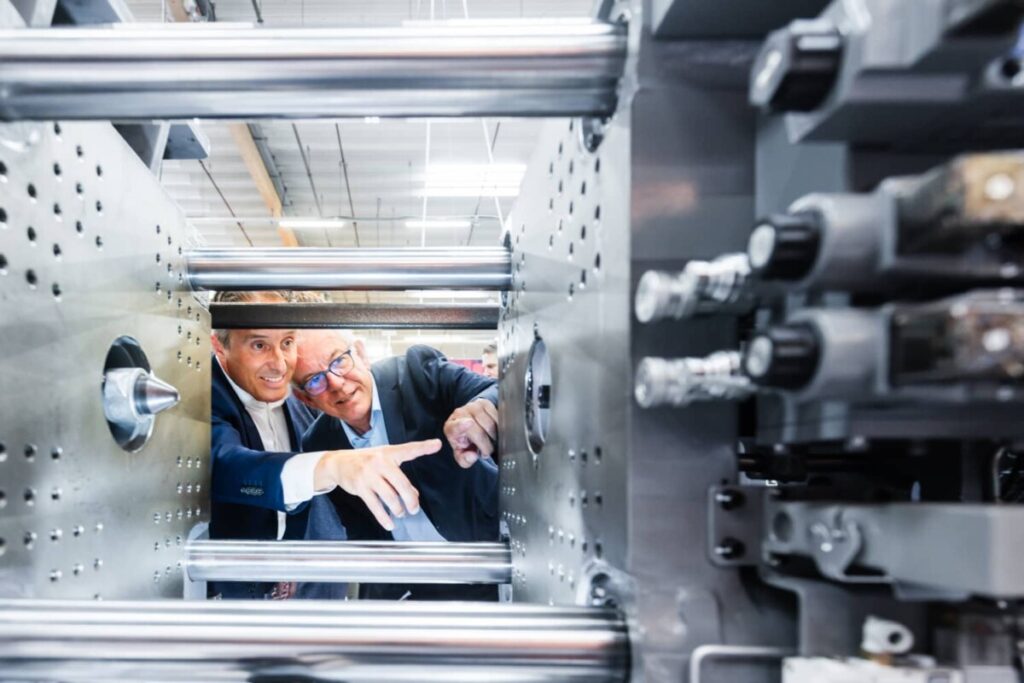 Zwei m&auml;nnliche Messebesucher der KUTENO in Bad Salzuflen analysieren die Technik eines Spritzgusswerkzeuges im Detail.