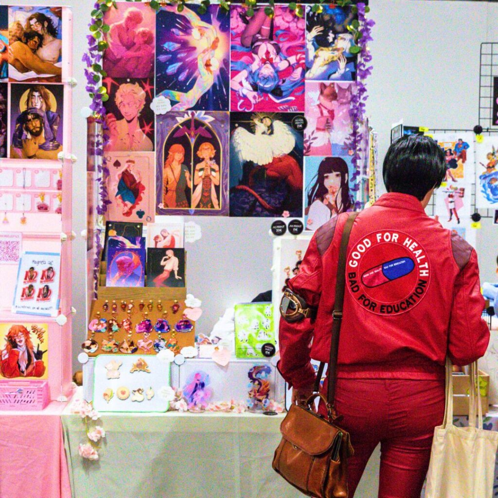 Person in Akira cosplay looking at products in Artist Alley