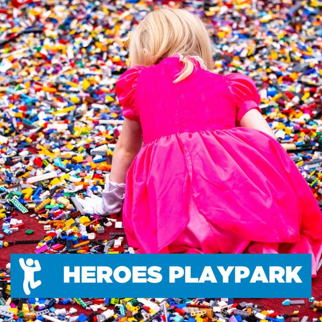 Picutre of girl playing with lego from behing. Overlaid there is a blue banner reading "Heros Playpark"