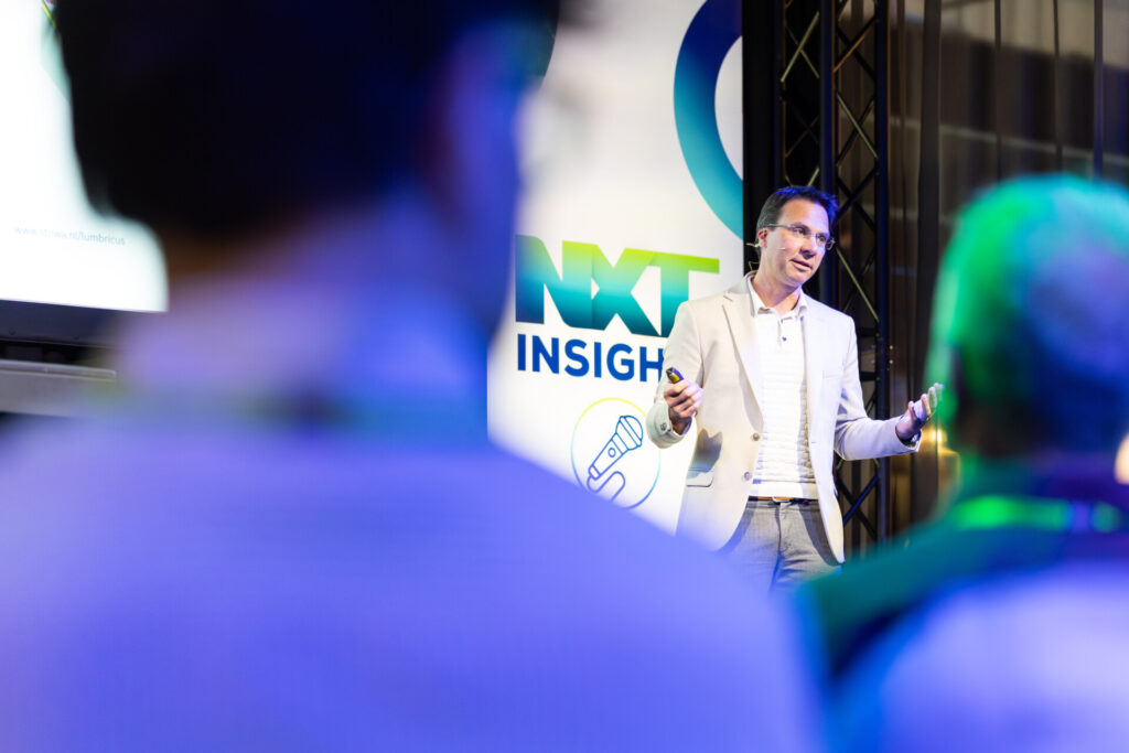 Spreker presenteert op NXT Insight-evenement voor publiek