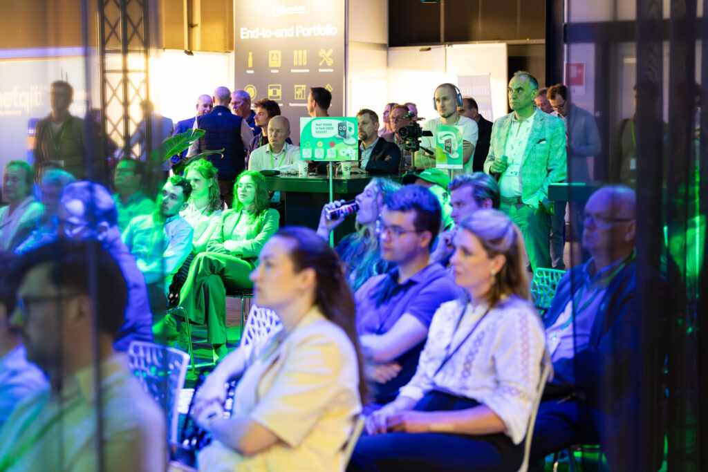 Publiek bij technologiepresentatie onder groen-blauw licht