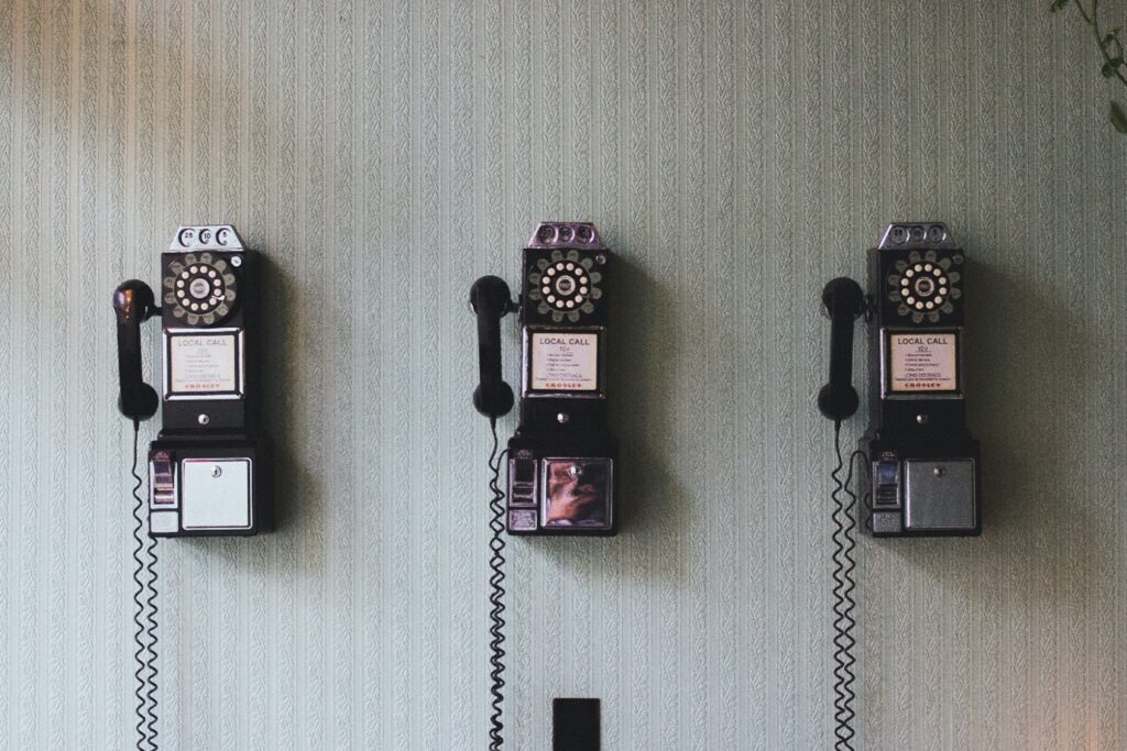 muur met behangpapier en oude telefoons