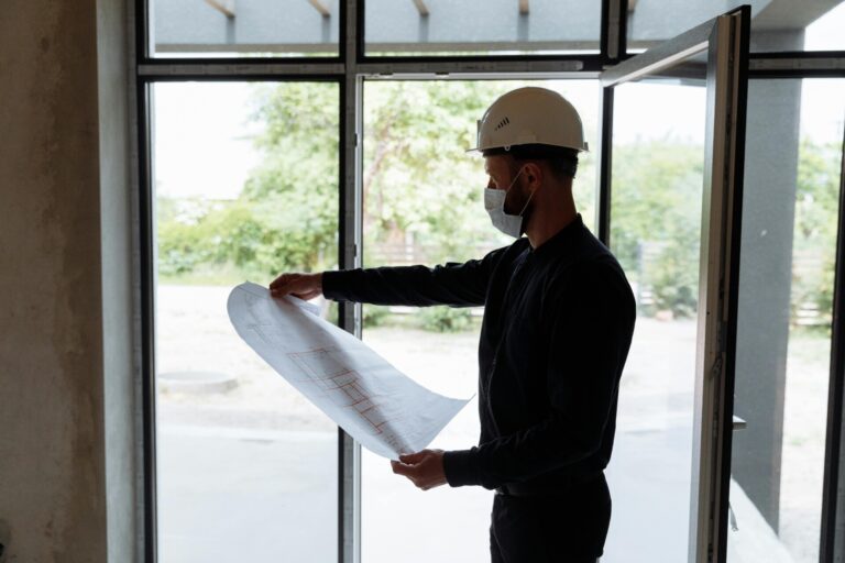 Ingenieur die naar een grondplan kijkt