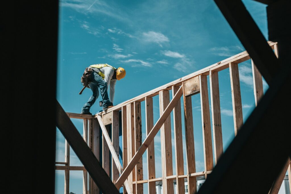 Man werkt aan houten frame voor een huis