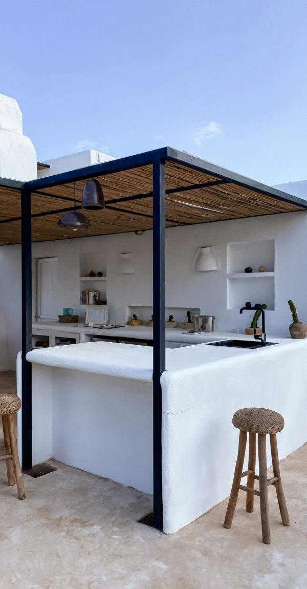 Mediterraanse buitenkeuken met witte muren en overkapping