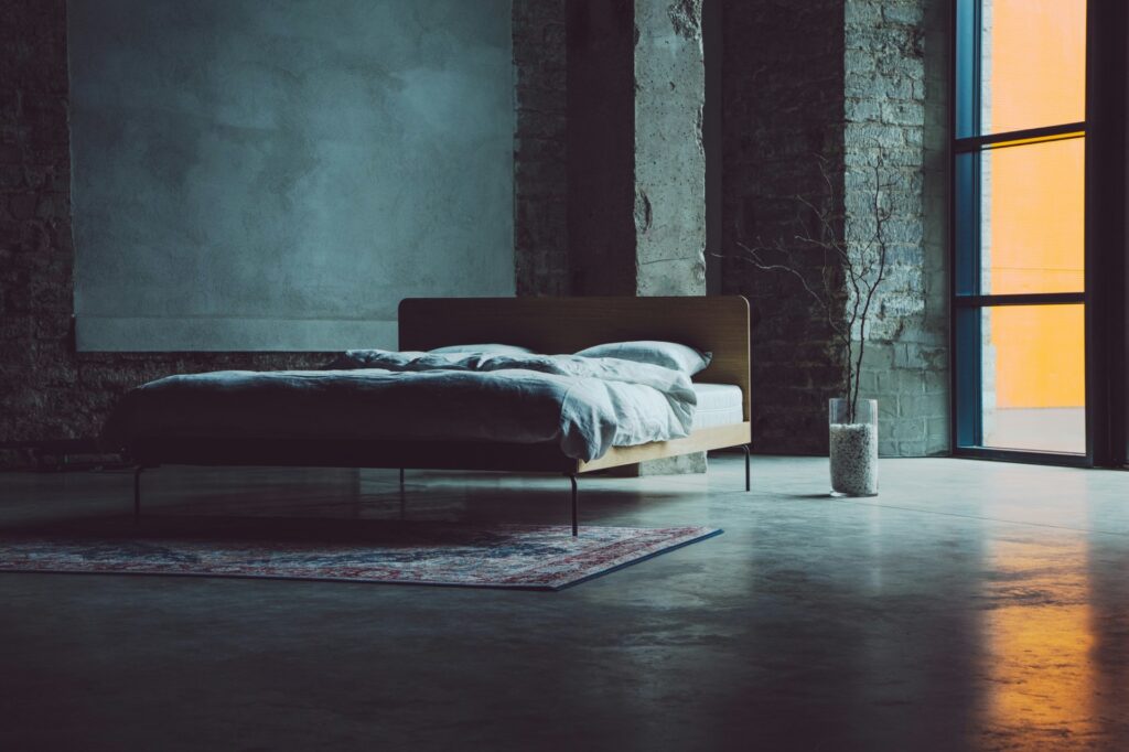 Bed in een kamer van beton en baksteen