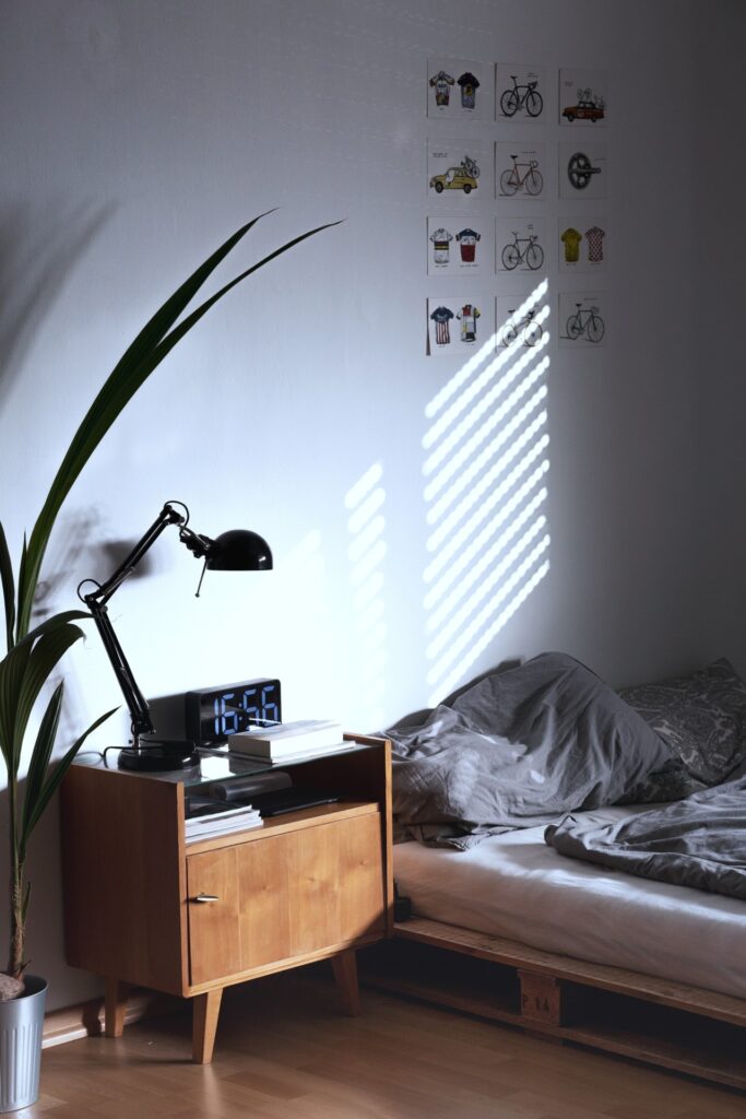 kamer met bed op palletten en en houten nachtkastje