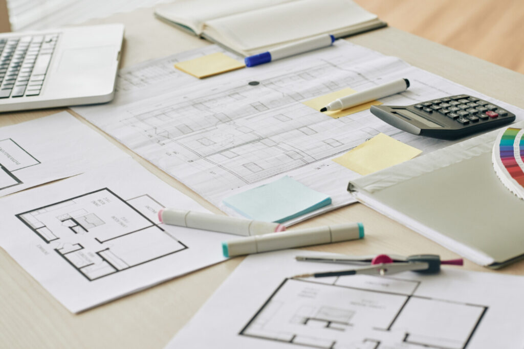 Werkblad met een paar grondplannen van het interieur van een woning en ontwerpgerief van een architect.