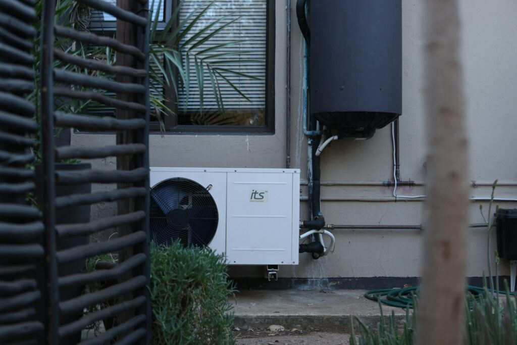 Warmtepomp die buiten staat, verbonden met een boiler.