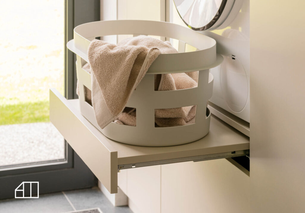 Wasmand op uitklapbare schap onder wasmachine.