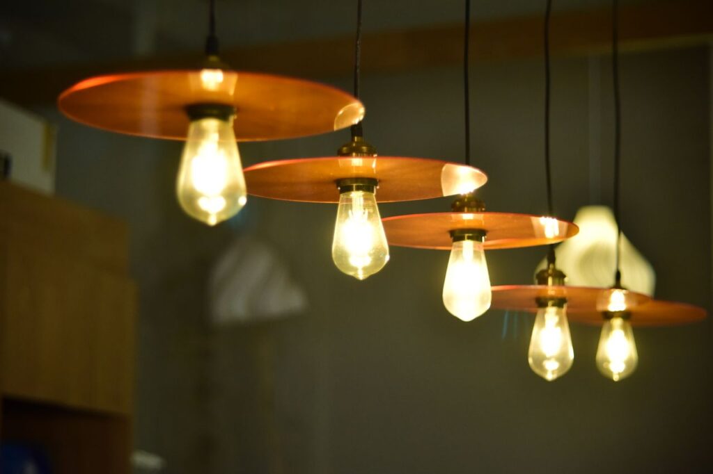 Een rij van vijf hanglampen met koperkleurig accent.