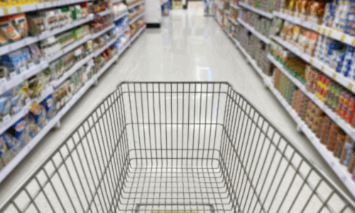 A shopping cart in a supermarket aisle surrounded by products, highlighting the impact of packaging design on brand identity and customer experience