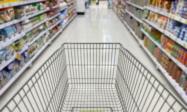 A shopping cart in a supermarket aisle surrounded by products, highlighting the impact of packaging design on brand identity and customer experience