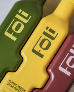 Close-up of FOLI’s green, yellow and burgundy interlocking bottles, highlighting the distinctive registered packaging design.
