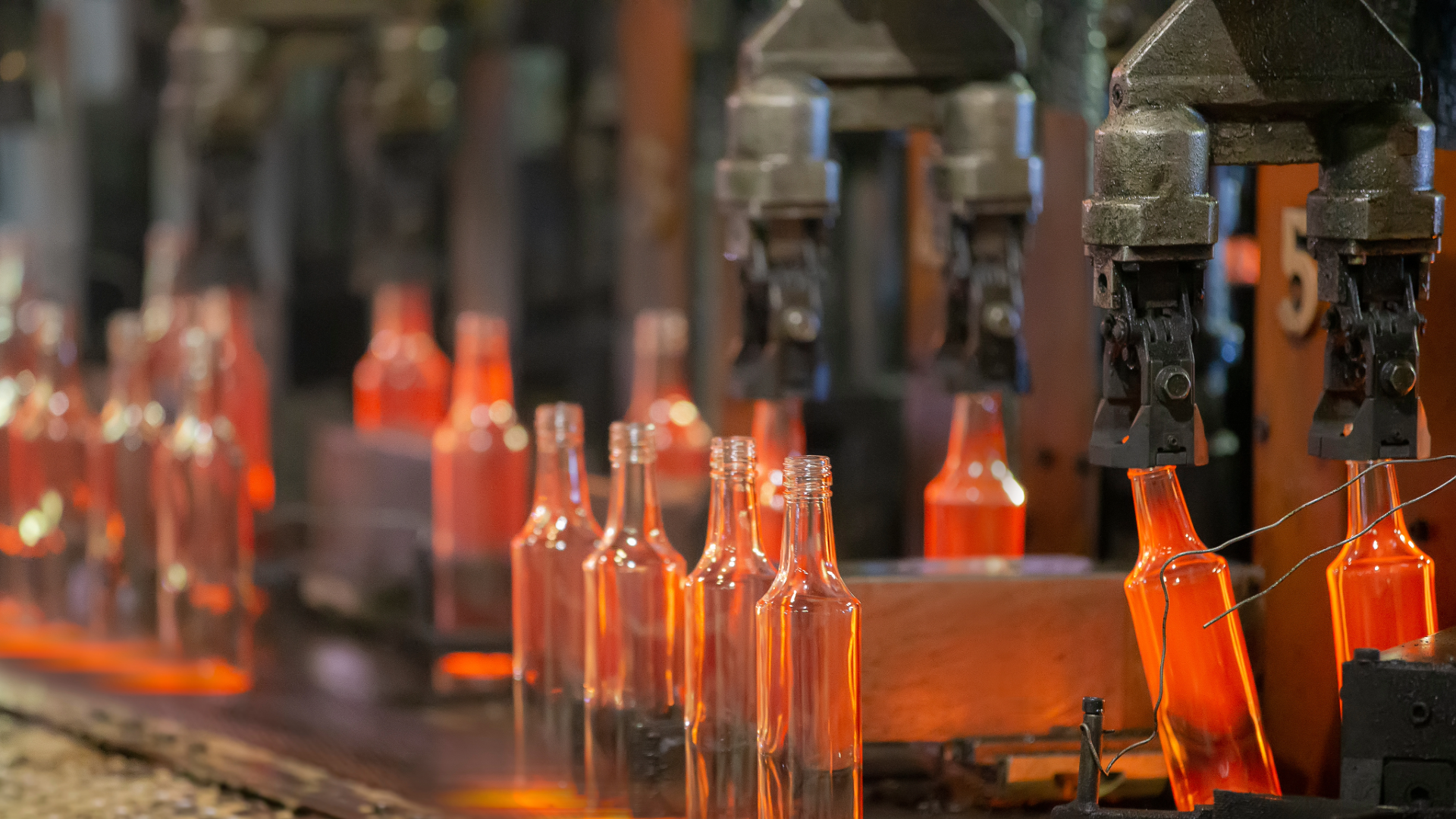 Glass bottles being manufactured on a production line as part of more sustainable glassmaking practices