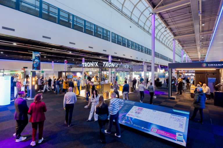 Overzicht van de beursvloer, gevuld met bezoekers