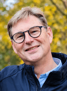 Glimlachende man met bril in herfstachtig park